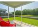 Relaxing screened porch with red Adirondack chairs, views of landscaped backyard and community pond at 1689 Eider Down Dr, Summerville, SC 29483