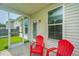 Charming screened porch with red Adirondack chairs, ideal for outdoor relaxation and enjoying views at 1689 Eider Down Dr, Summerville, SC 29483