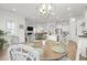 Open concept dining area features a round table, decorative chairs, and a modern chandelier adjacent to the kitchen and living room at 1832 Agate Bay Dr, Mount Pleasant, SC 29466