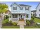 Charming light blue two-story home featuring a cozy front porch and well-manicured lawn at 1832 Agate Bay Dr, Mount Pleasant, SC 29466