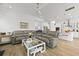 Open-concept living room with a gray sectional, glass coffee table, and views of the kitchen and dining area at 1832 Agate Bay Dr, Mount Pleasant, SC 29466