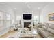 Cozy living room with a fireplace, gray seating, a glass coffee table, and ample natural light from the large windows at 1832 Agate Bay Dr, Mount Pleasant, SC 29466