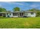 Large backyard with a screened-in porch and lush lawn under a bright, blue sky at 1917 Piper Dr, Charleston, SC 29407
