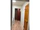Hallway with wood-look floors leads to a storage cabinet, with a wood door on the right at 1917 Piper Dr, Charleston, SC 29407