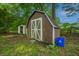 Storage shed in backyard, built with wood paneling, and white trim doors at 1917 Piper Dr, Charleston, SC 29407