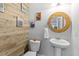 Powder room with unique wood wall, a pedestal sink and a decorative round mirror at 1928 Mossdale Dr, Johns Island, SC 29455