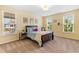 Bedroom with neutral carpet, a bed with blue and tan patterned bedding, and three windows at 1928 Mossdale Dr, Johns Island, SC 29455