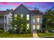 Charming two-story home with a cozy front porch, fresh landscaping, and twilight sky at 1928 Mossdale Dr, Johns Island, SC 29455