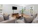 A cozy living room featuring comfortable seating, a large TV, and natural light at 1928 Mossdale Dr, Johns Island, SC 29455