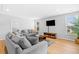 Bright living room featuring wood floors, stylish gray sofas, and recessed lighting at 1928 Mossdale Dr, Johns Island, SC 29455