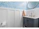 A powder room with blue patterned wallpaper, wainscoting, and a navy blue vanity at 205 White Gables Dr, Summerville, SC 29483