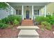 Charming two-story home featuring a cozy front porch, manicured lawn, and a welcoming landscaped yard at 205 White Gables Dr, Summerville, SC 29483