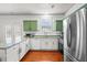 Bright kitchen boasts stainless appliances, granite counters and white cabinetry with green accent cabinets at 205 White Gables Dr, Summerville, SC 29483