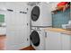 Laundry room with stacked washer and dryer, storage cabinets, and tiled backsplash at 205 White Gables Dr, Summerville, SC 29483