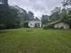Expansive backyard with lush lawn and foliage and a view of a white home and garage at 207 Cedar St, Saint George, SC 29477