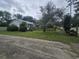 View of a home with a front yard, mature trees, and a walking ramp at 207 Cedar St, Saint George, SC 29477