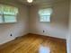 Bright bedroom with hardwood floors, two windows with lace curtains, and neutral wall paint at 2163 Pinehurst Ave, Charleston, SC 29414