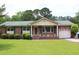 Charming single-story brick home with green roof, lush lawn, and attached garage at 2163 Pinehurst Ave, Charleston, SC 29414