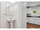 View from bathroom into the kitchen, which features white cabinetry and hardwood floors at 22 Ogier St, Charleston, SC 29403