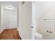 Hallway with hardwood floors and a view into the half bathroom featuring a white toilet at 22 Ogier St, Charleston, SC 29403