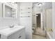 Bright bathroom featuring tile floor, vanity with sink, mirror, and glass shelving for storage at 22 Ogier St, Charleston, SC 29403