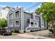 View of the gray two-story townhomes featuring a modern design, landscaping, and parking at 22 Ogier St, Charleston, SC 29403
