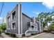 View of the gray two-story townhomes with a modern design under a bright blue sky at 22 Ogier St, Charleston, SC 29403