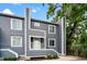 Charming gray two-story home with a small porch and lush green landscaping under a blue sky at 22 Ogier St, Charleston, SC 29403