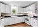 Charming kitchen featuring white cabinets, matching appliances, and a unique diamond-shaped window at 22 Ogier St, Charleston, SC 29403