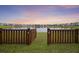 Scenic view of a pond and surrounding neighborhood through a wooden fence, offering a serene backdrop at 228 Lucca Dr, Summerville, SC 29486