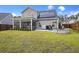 Beautifully landscaped backyard featuring a screened-in porch, stone patio, and fire pit area at 228 Lucca Dr, Summerville, SC 29486
