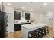 Open-concept kitchen boasts a spacious island, dark cabinets, and modern pendant lighting at 228 Lucca Dr, Summerville, SC 29486