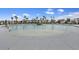 A luxurious community pool surrounded by lounge chairs and palm trees at 228 Lucca Dr, Summerville, SC 29486
