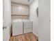 Laundry room with wooden floors, washer, dryer, and wall-mounted storage cabinets at 242 Torslanda Ln, Summerville, SC 29486