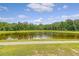 Scenic view of the pond with lush green trees and a sidewalk path at 242 Torslanda Ln, Summerville, SC 29486