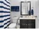 Half bath with gray walls, dark vanity, framed mirror, striped shower curtain, and boat decoration at 255 Decatur Dr, Summerville, SC 29486