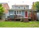 Exterior view of a house with a red door, a deck, an outdoor shower, and lush landscaping in the backyard at 293 Grove St, Charleston, SC 29403