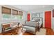 Bedroom with light blue walls, hardwood floors, a workspace, and pops of red at 293 Grove St, Charleston, SC 29403