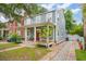 Charming two-story home with a inviting front porch and brick walkway, set against a backdrop of lush greenery at 293 Grove St, Charleston, SC 29403