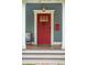 Close-up of a bright red front door, adorned with a unique elephant knocker and a vintage mailbox at 293 Grove St, Charleston, SC 29403