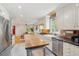 Bright kitchen with stainless steel appliances, custom island, and view to an eat-in dining area at 293 Grove St, Charleston, SC 29403