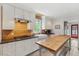 Bright kitchen featuring white cabinetry, stone countertops, a center island, and modern appliances for a seamless cooking experience at 293 Grove St, Charleston, SC 29403