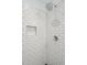 Close-up of the sleek subway-tiled shower with chrome fixtures and a built-in niche at 293 Grove St, Charleston, SC 29403