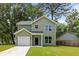 Charming two-story home with light green siding, a well-maintained lawn, and an attached one-car garage at 2960 Blackfish Rd, Johns Island, SC 29455