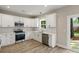 A bright kitchen with stainless appliances, quartz countertops, subway backsplash, and vinyl plank flooring at 2960 Blackfish Rd, Johns Island, SC 29455
