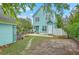 Expansive backyard featuring lush greenery, a brick fire pit, and a turquoise home with a white picket fence at 300 Foxglove Ave, Summerville, SC 29483