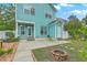 Inviting backyard with a fire pit, concrete patio, and a charming turquoise home exterior at 300 Foxglove Ave, Summerville, SC 29483