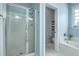 Bright blue bathroom featuring glass shower door, soaking tub, and view of the toilet and shelving at 300 Foxglove Ave, Summerville, SC 29483