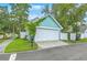 Detached garage showcasing a well-maintained lawn, white door, and the home's turquoise siding at 300 Foxglove Ave, Summerville, SC 29483