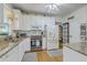 Updated kitchen features white cabinets, granite counters, stainless appliances, and tile backsplash at 300 Foxglove Ave, Summerville, SC 29483